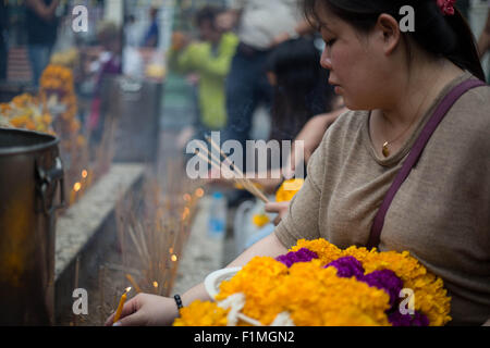 Bangkok, Thailand. 4. Sep, 2015. Eine Frau eine Kerze vor der Brahma-Statue an der Erawan-Schrein im Zentrum von Bangkok am 4. September 2015, nach der Wiederherstellung der beschädigten Statue vom 17. August Bombenanschlag die 20 Menschen getötet und verletzt mehr als Hunderte. Bildnachweis: Guillaume Payen/ZUMA Draht/Alamy Live-Nachrichten Stockfoto