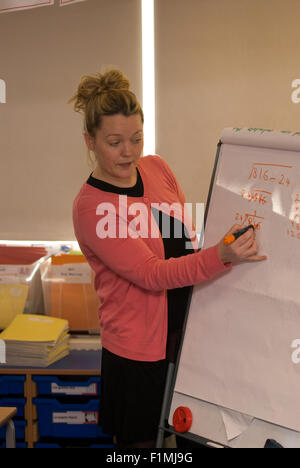 Weibliche Lehrer bei der Arbeit auf die Mathematik im Klassenzimmer, London, UK. Stockfoto