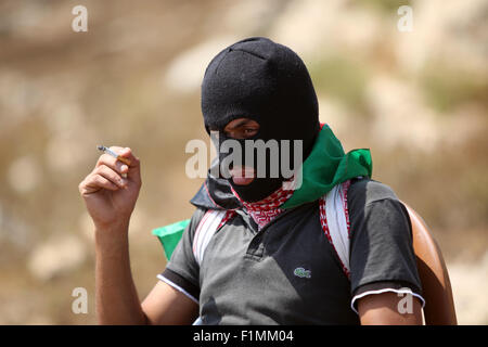 Nabi Saleh, Westjordanland, Palästinensische Gebiete. 4. Sep, 2015. Eine palästinensische Demonstranten raucht wie er beteiligt sich an einer Protestkundgebung gegen die jüdischen Siedlungen in der West Bank Dorf Nabi Saleh, in der Nähe von Ramallah Kredit-4. September 2015: Shadi Hatem/APA Bilder/ZUMA Draht/Alamy Live News Stockfoto