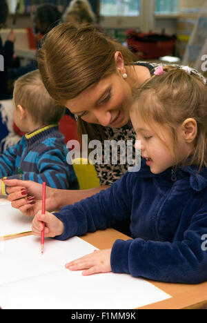 Grundschullehrerin, die Unterstützung der Schüler im Klassenzimmer, London, UK. Stockfoto