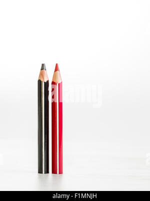 Rot, eine schwarze auf einem Holztisch vor einem weißen Hintergrund Bleistifte. Stockfoto