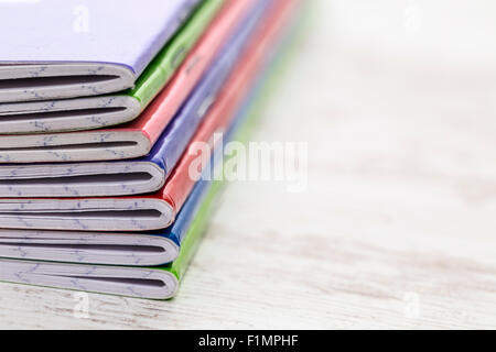 Nahaufnahme Bild aus einem Stapel von bunten Notebooks auf einem weißen Holztisch. Selektiven Fokus. Stockfoto