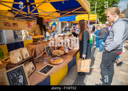 Eine Dame, die auf A Fudge und Kuchen Stall bei Wolverhampton Straße Markt West Midlands, UK Stockfoto