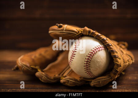 Braun Leder Baseballhandschuh auf einer Holzbank Stockfoto