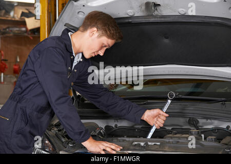 Lehrling Mechaniker In der Autowerkstatt arbeiten auf Auto-Motor Stockfoto