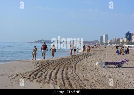 Suche entlang der Strand von San Juan Playa in Richtung Alicante, mit Menschen zu Fuß an der Küste, am frühen Morgen. Alicante, Spanien Stockfoto