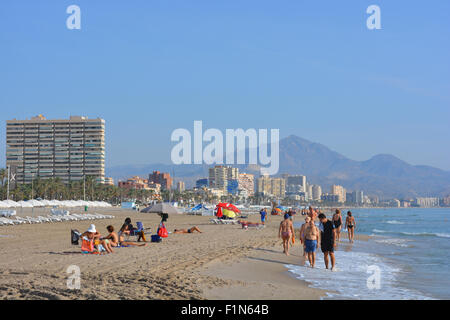 Suche entlang der Strand von San Juan Playa in Richtung Campello, mit Menschen zu Fuß an der Küste, am frühen Morgen. Alicante, Spanien Stockfoto