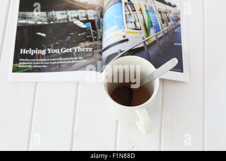 Lesen besuchen Sie Melbourne Broschüre bei einer Tasse Kaffee Stockfoto