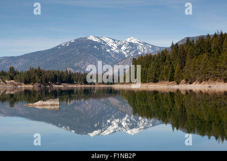 Die schneebedeckte Kabinett Bergen reflektiert in den ruhigen Gewässern der Trout Creek mit einem grünen Baum Küstenlinie. Stockfoto