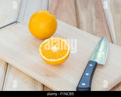 Frisch geschnittenen Sie Orangen mit Messer auf Holz Schneidebrett Stockfoto