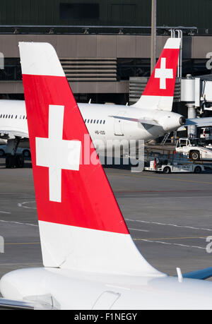 Das Schweizer Kreuz auf den Flossen zwei Flugzeuge der Swiss International Air Lines am internationalen Flughafen Zürich-Kloten. Stockfoto