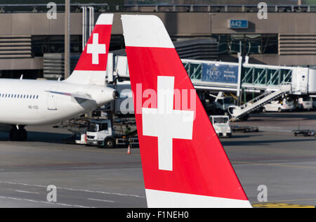 Das Schweizer Kreuz auf den Flossen zwei Flugzeuge der Swiss International Air Lines am internationalen Flughafen Zürich-Kloten. Stockfoto