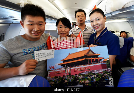 (150905)--Peking, 5. September 2015 (Xinhua)--A Flight Attendant (R) zeigt Fotos von Peking Day Parade auf dem Flug CZ6366 von Peking, Hauptstadt von China, nach Haikou, der Hauptstadt der Provinz Süd-China Hainan, 5. September 2015. China Southern Airlines begann eine Veranstaltung namens "In Gedenken an Peking Day Parade" auf einem Flug von Beijing-Haikou Samstag, Parade Fotos für Passagiere. China am Donnerstag statt Gedenken Aktivitäten, einschließlich einer großen Militärparade anlässlich der 70. Jahrestag des Sieges von dem chinesischen Volk Krieg des Widerstands gegen die japanische Aggression und die Stockfoto