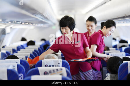 (150905)--Peking, 5. September 2015 (Xinhua)--Flugbegleiter senden Nationalflaggen, Passagiere auf Flug CZ6366 von Peking, die Hauptstadt von China nach Haikou, der Hauptstadt der Provinz Süd-China Hainan, 5. September 2015. China Southern Airlines begann eine Veranstaltung namens "In Gedenken an Peking Day Parade" auf einem Flug von Beijing-Haikou Samstag, Parade Fotos für Passagiere. China am Donnerstag statt Gedenken Aktivitäten, einschließlich einer großen Militärparade anlässlich der 70. Jahrestag des Sieges von dem chinesischen Volk Krieg des Widerstands gegen die japanische Aggression und der Welt ein Stockfoto