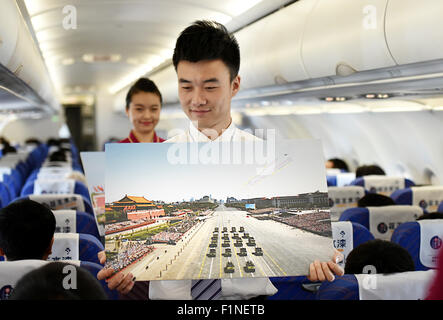 (150905)--Peking, 5. September 2015 (Xinhua)--A Flight Attendant zeigt Fotos von Peking Day Parade auf dem Flug CZ6366 von Peking, Hauptstadt von China, nach Haikou, der Hauptstadt der Provinz Süd-China Hainan, 5. September 2015. China Southern Airlines begann eine Veranstaltung namens "In Gedenken an Peking Day Parade" auf einem Flug von Beijing-Haikou Samstag, Parade Fotos für Passagiere. China am Donnerstag statt Gedenken Aktivitäten, einschließlich einer großen Militärparade anlässlich der 70. Jahrestag des Sieges von dem chinesischen Volk Krieg des Widerstands gegen die japanische Aggression und die Wor Stockfoto