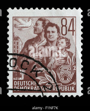 Briefmarke gedruckt in der DDR, zeigt eine Familienserie 5-Jahresplan, ca. 1955 Stockfoto