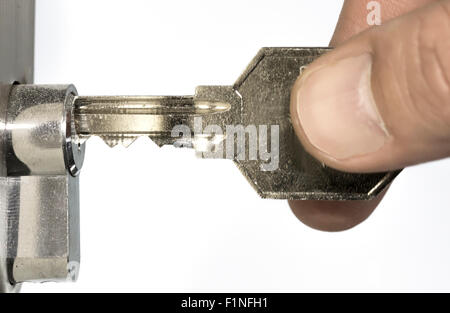 Menschliche Finger einfügen Schlüssel in das Türschloss Stockfoto