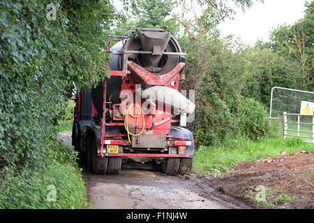 Entladen einen konkreten LKW in einen schmalen Feldweg für eine farm Stockfoto