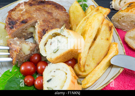 Hamburger-Steak mit Kartoffeln, Tomaten und Oliven Brot auf dem Silbertablett serviert Stockfoto