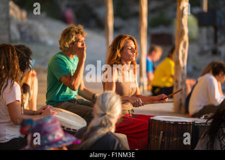 Menschen, die Trommeln bei Sonnenuntergang am Strand von Benirras, Ibiza, Stockfoto