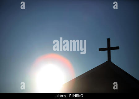 Symbolische Sonne und Kapelle mit Holzkreuz Stockfoto