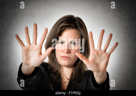 Business-Frau im schwarzen Anzug hält beide Hand, etwas oder jemanden zu stoppen Stockfoto