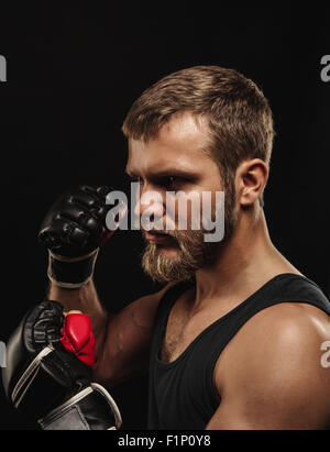 Athletische bärtigen Boxer mit Handschuhen auf dunklem Hintergrund Stockfoto