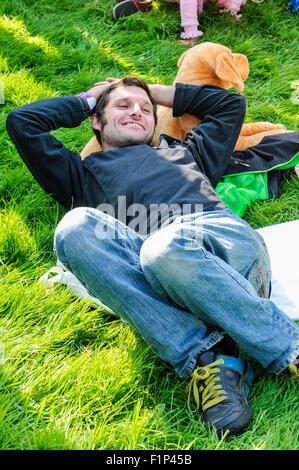 Motorradfahrer und Fernsehmoderator Guy Martin (Tyco BMW Motorrad Racing) ruht auf dem Rasen, wie er das Hillsborough International Oyster Festival besucht. Stockfoto