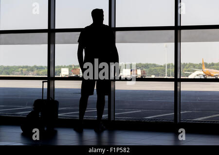 Silhouette Mann am Flughafen vor Fenster Stockfoto