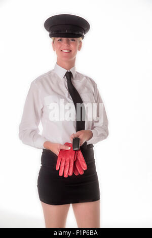 Ein uniformierter Chauffeuse stehend in einem Minirock trägt einen schwarzen Hut und treibende Handschuhe hält. Einem professionellen weiblichen chauffeur Stockfoto