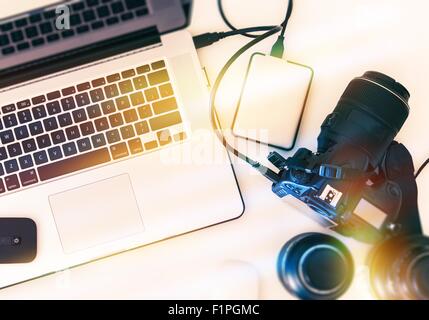 Digitale Fotografie-Workstation von oben. Moderne digitale Kamera, objektive und Laptop-Computer. Stockfoto