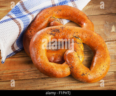 Frisch gebackene weiche Brezeln auf einem Holztisch. Ansicht von oben Stockfoto