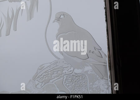 Detail der Eucharistie Fenster, St. Columba Kapelle, Bischofshaus, Iona. Gravierte sandgestrahlt Bild einer Taube oder Taube. Stockfoto