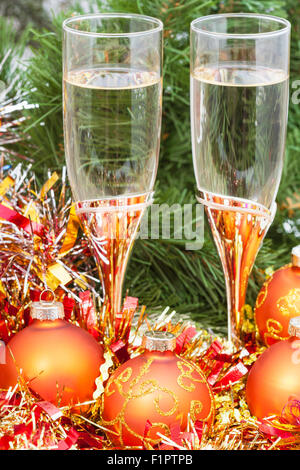 Weihnachten-Stillleben - goldene Xmas Kugeln und Lametta und zwei Gläser Sekt auf Weihnachtsbaum Hintergrund Stockfoto