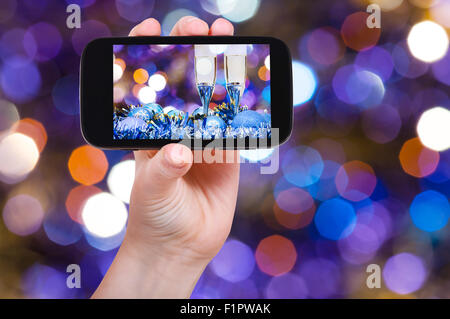 Mann nimmt Foto von Weihnachten Stillleben - zwei Gläser Champagner blau Weihnachten Dekorationen mit dunklem Violett und rot verwischt Chr Stockfoto