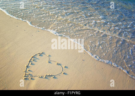 Herzen in den Sand gezeichnet. Strand Hintergrund. Ansicht von oben Stockfoto