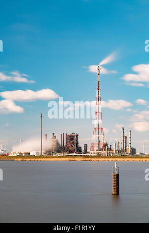 Lange Exposition Schuss einer Raffinerie mit hohen Fackel Stack in den Hafen von Antwerpen, erhebt sich Belgien mit vielen der Destillation. Stockfoto