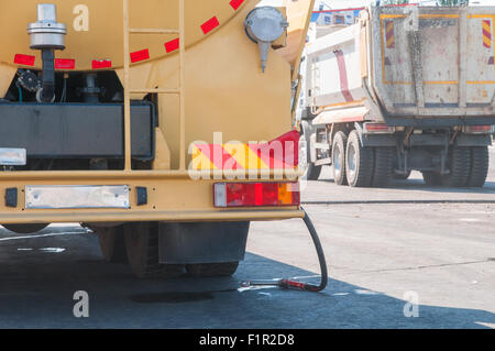 Fahrzeuge auf der Straßenbaustelle - Wasser Tank und Muldenkipper Stockfoto