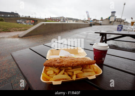 frittierte billige Fish &amp; Chips an einem nassen Sommertag an einem Badeort in Nord Wales uk Stockfoto