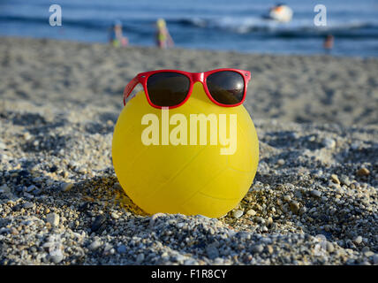 Ball im Sonnenbrille auf Sommerstrand Stockfoto