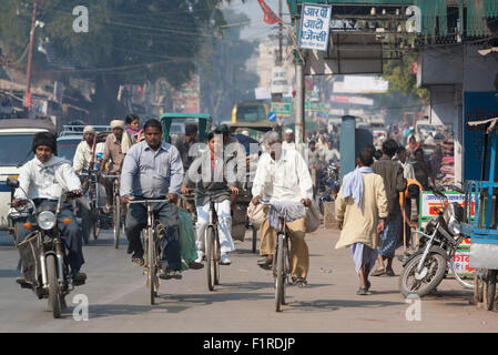 Radfahrer und andere Verkehrsteilnehmer auf überfüllt, staubigen Raja Bazar Rd in Varanasi, Indien Stockfoto