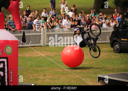 BMX-Stunt-Fahrer vorne weg von einem roten bouncy Ball spiegeln Stockfoto