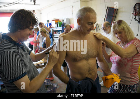 Isle Of Wight, UK, Samstag, 15. August 2015. Mitglieder des London Polytechnic Teams auf der jährlichen Sandown, Shanklin schwimmen. Sandown, Shanklin Meer schwimmen ist Gezeiten betreutes Schwimmen 2 Meile auch bekannt als das Pier, Pier-schwimmen. Registrierung und Nummerierung. Stockfoto