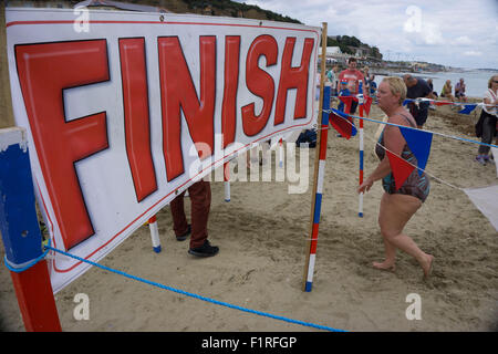 Isle Of Wight, UK, Samstag, 15. August 2015. Mitglieder des London Polytechnic Teams auf der jährlichen Sandown, Shanklin schwimmen. Sandown, Shanklin Meer schwimmen ist Gezeiten betreutes Schwimmen 2 Meile auch bekannt als das Pier, Pier-schwimmen. Ziellinie. Stockfoto