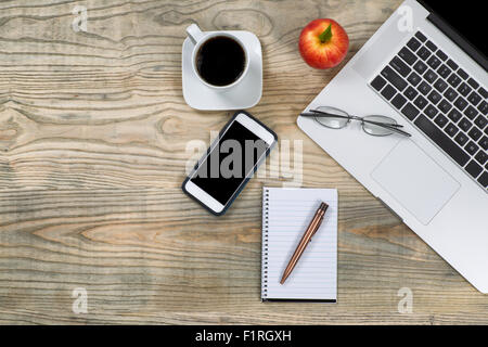 Draufsicht eines organisierten, etwas Alterung, hölzerne Desktops mit Apfel und Kaffee für Pause. Viele Textfreiraum. Stockfoto