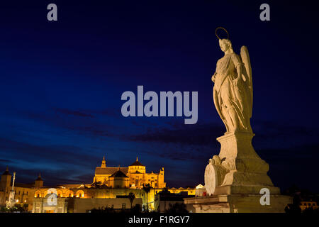 Statue von Saint Raphael in der Abenddämmerung auf der römischen Brücke von Cordoba mit Moschee-Kathedrale Stockfoto