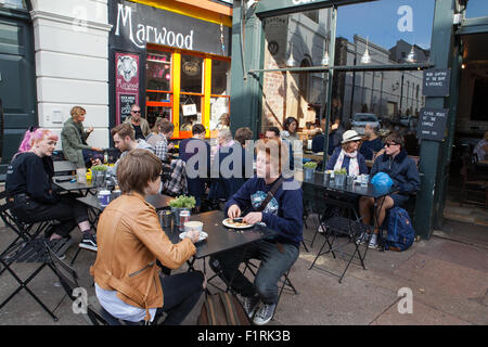 Kunden sitzen außerhalb der Marwood und Cafe Coho Coffee-Shops in Brighton Stockfoto