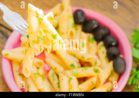 Italienische Nudeln mit Tomatensauce auf einer Gabel im Sonnenlicht Stockfoto