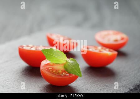 in halben Kirschtomaten auf Schiefer Brett geschnitten Stockfoto