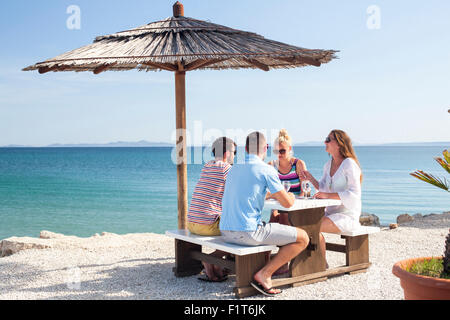 Gruppe von Freunden am Tisch in der Beachbar Stockfoto